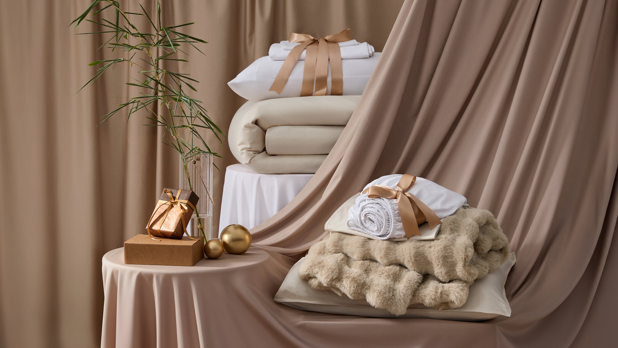Luxury bedding gift set with premium blankets and throws featuring elegant ribbon packaging for Black Friday deals