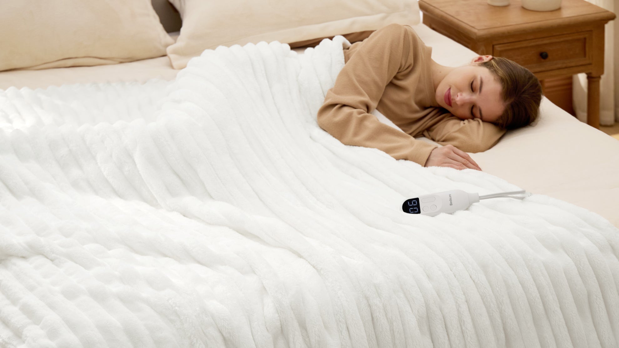 Woman sleeping peacefully on white heated blanket in bedroom, demonstrating effective bedtime routine for healthy circadian rhythm and quality rest