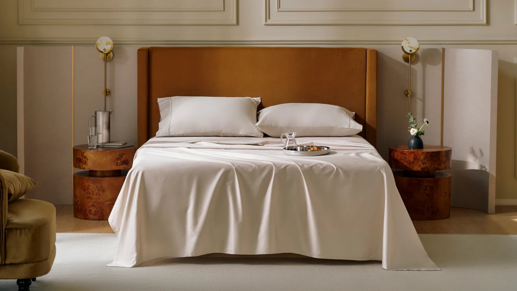 A neatly made bed featuring breathable, light-colored natural fiber sheets and supportive pillows, resting against a brown headboard, perfectly illustrating the essential bedding features for a comfortable night's sleep.	