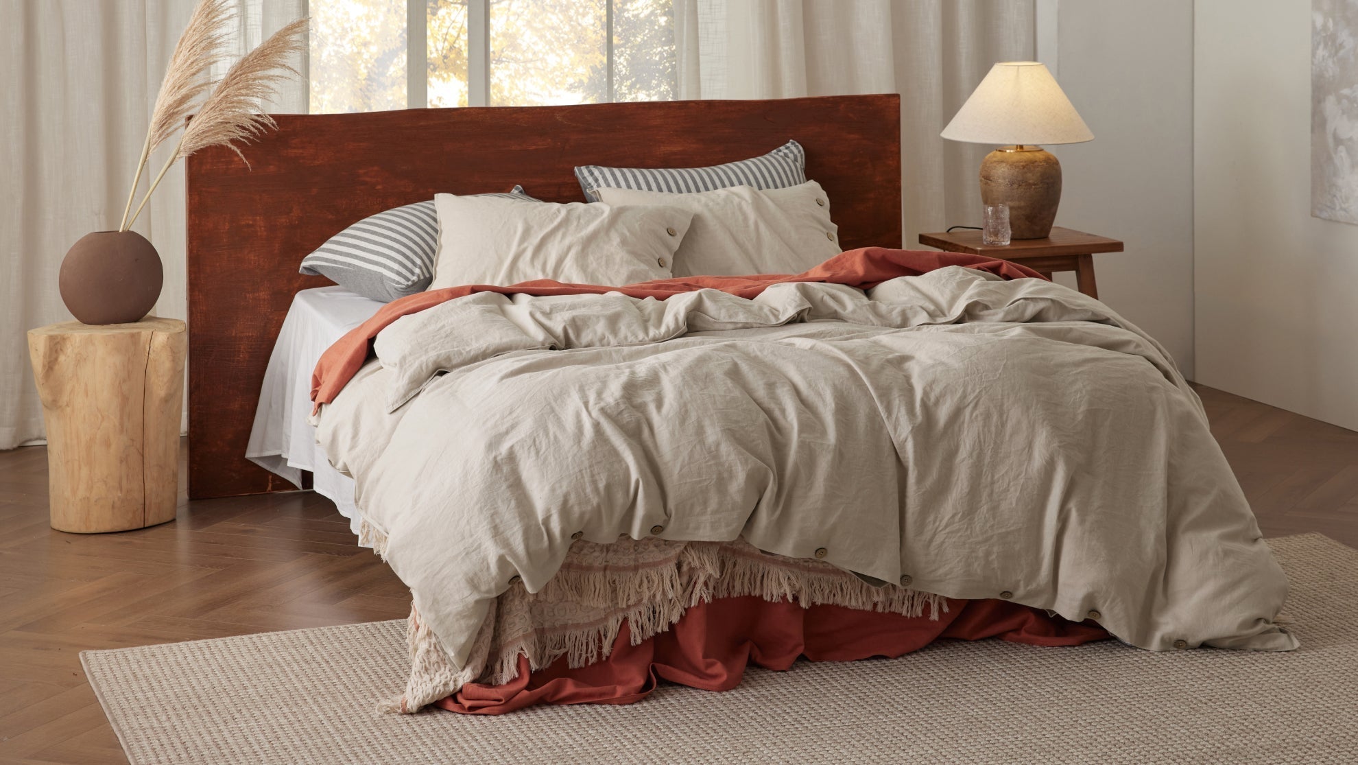 Warm autumn bedroom sanctuary featuring layered bedding, cotton duvet covers, and fall textiles for seasonal decorating