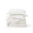 Stacked white PureWoven™ 100% cotton muslin duvet cover and shams.