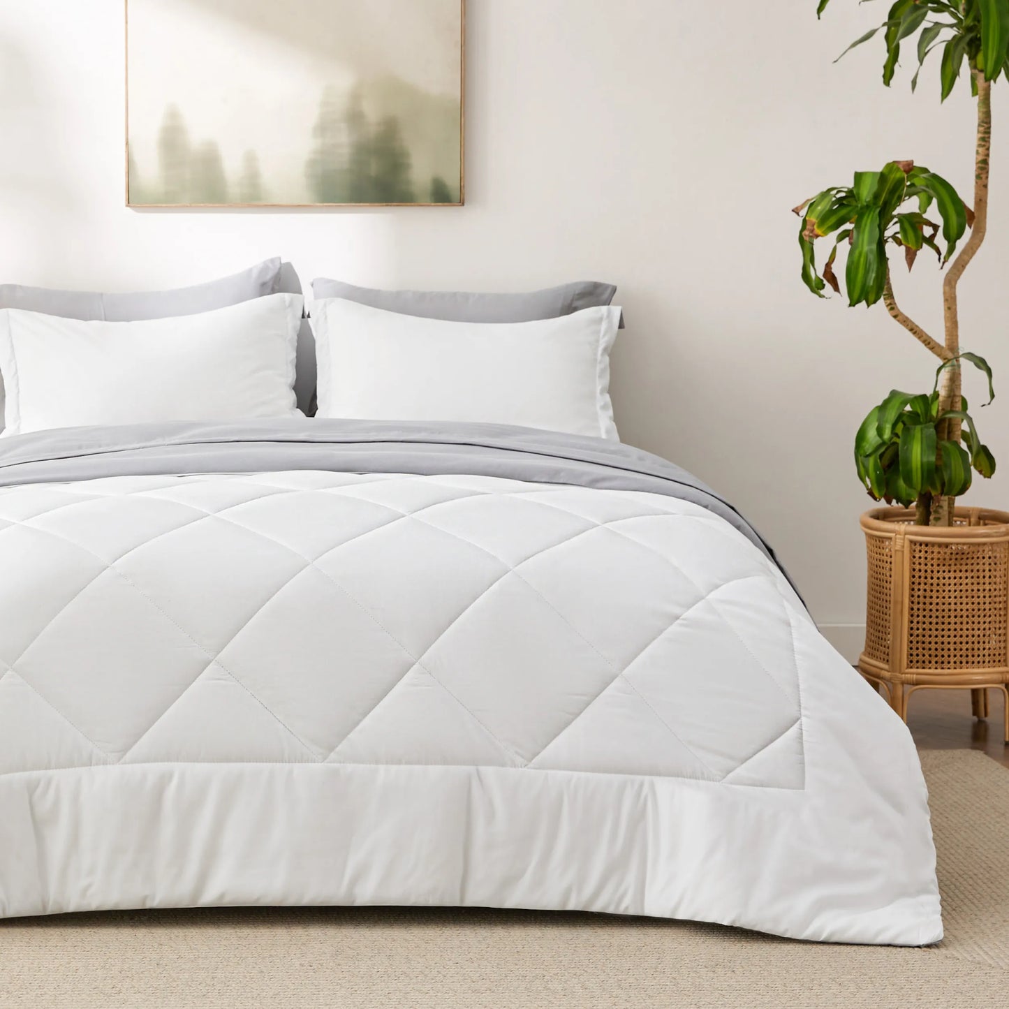 White diamond-quilted comforter and grey bedding on bed; part of reversible bed-in-a-bag set.