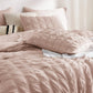 Blush pink seersucker plaid comforter set with textured pattern and decorative pillows.