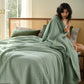 PureWoven light green 100% cotton 8-layer gauze blanket with diamond quilting texture.