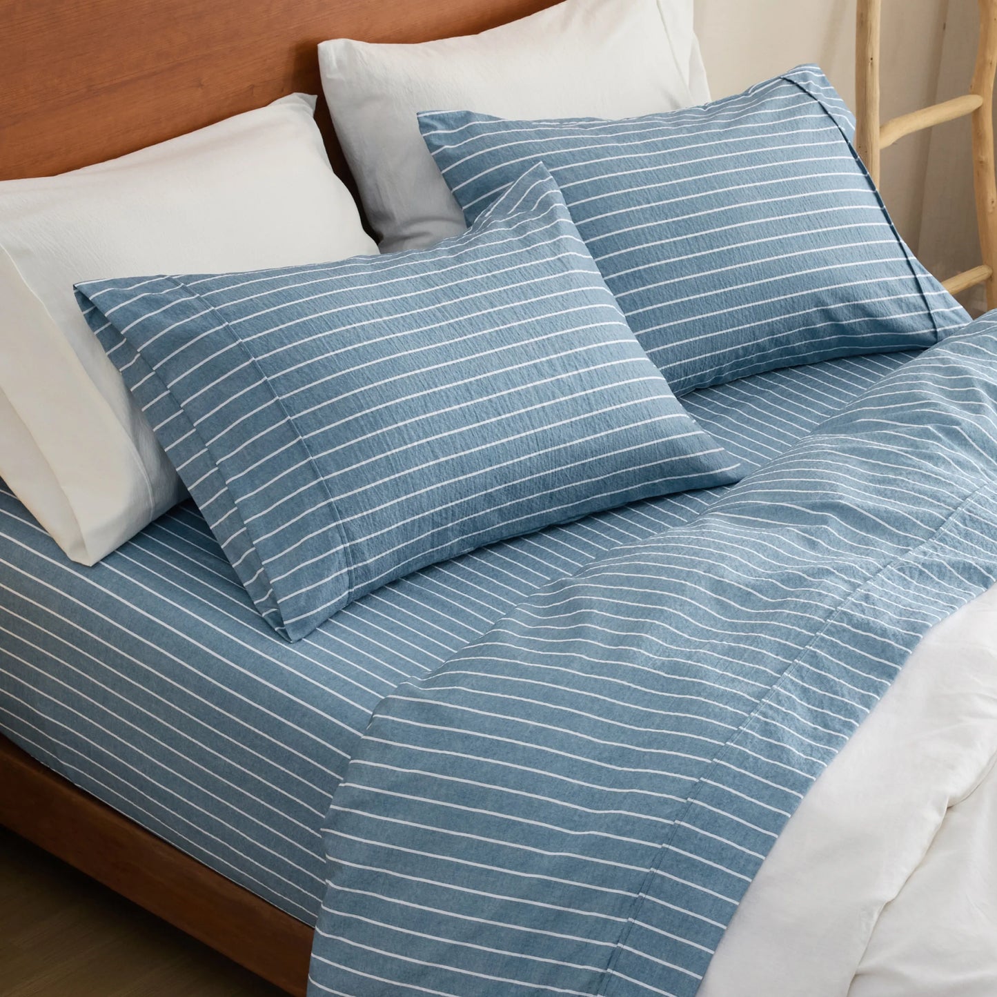 Cotton-like blue and white striped polyester sheet set on bed.