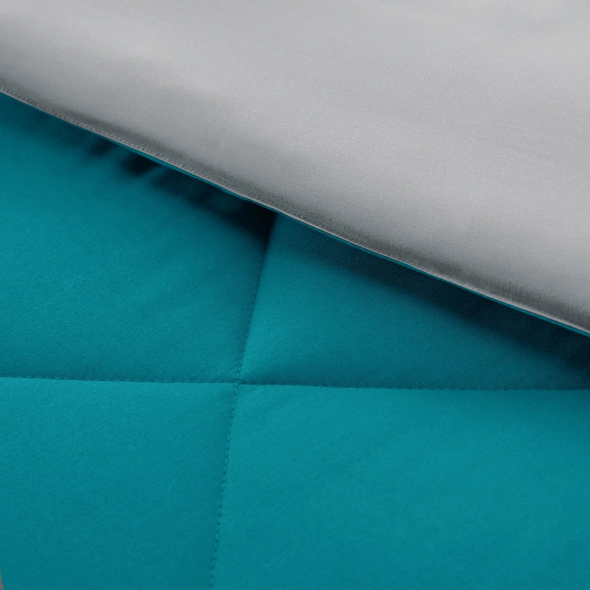 Teal and silver reversible comforter detail showing diamond quilting. Microfiber bedding.