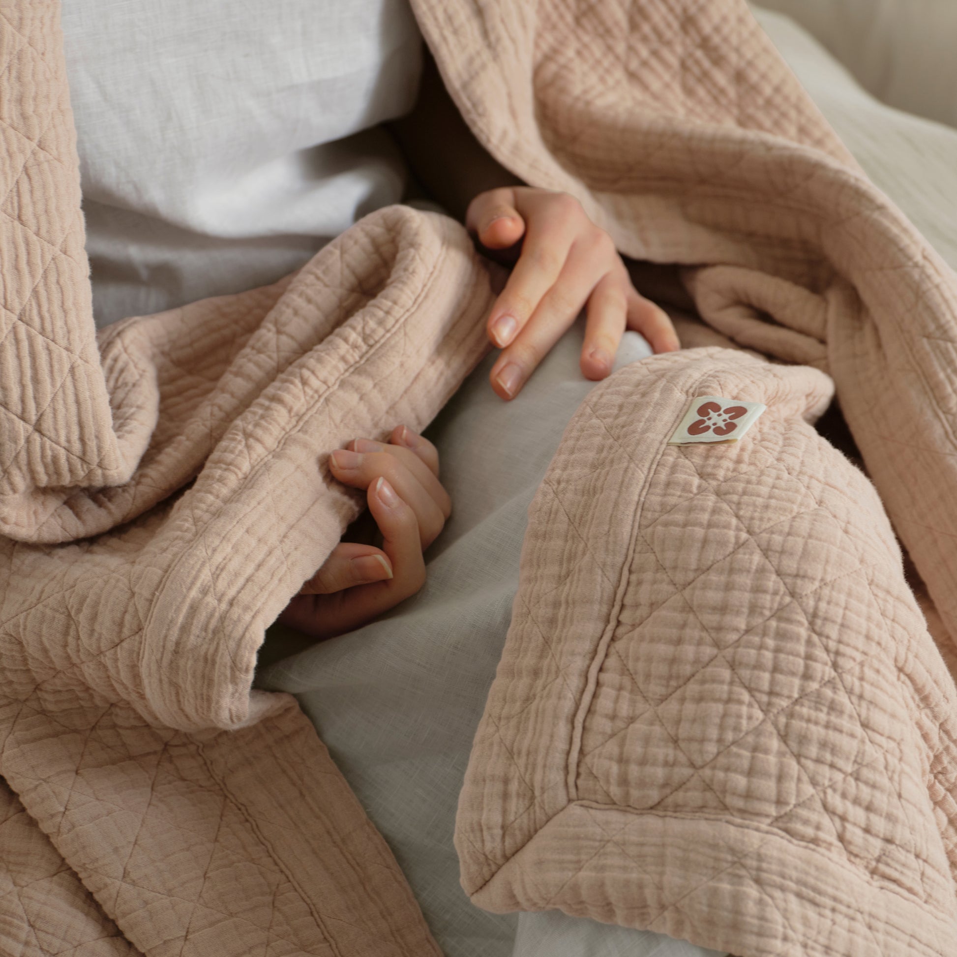 PureWoven™ 8-layer cotton gauze blanket in blush pink, with diamond quilting and soft texture.