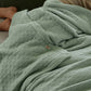 Sage green PureWoven™ 8-layer cotton gauze blanket with diamond quilting, soft texture.
