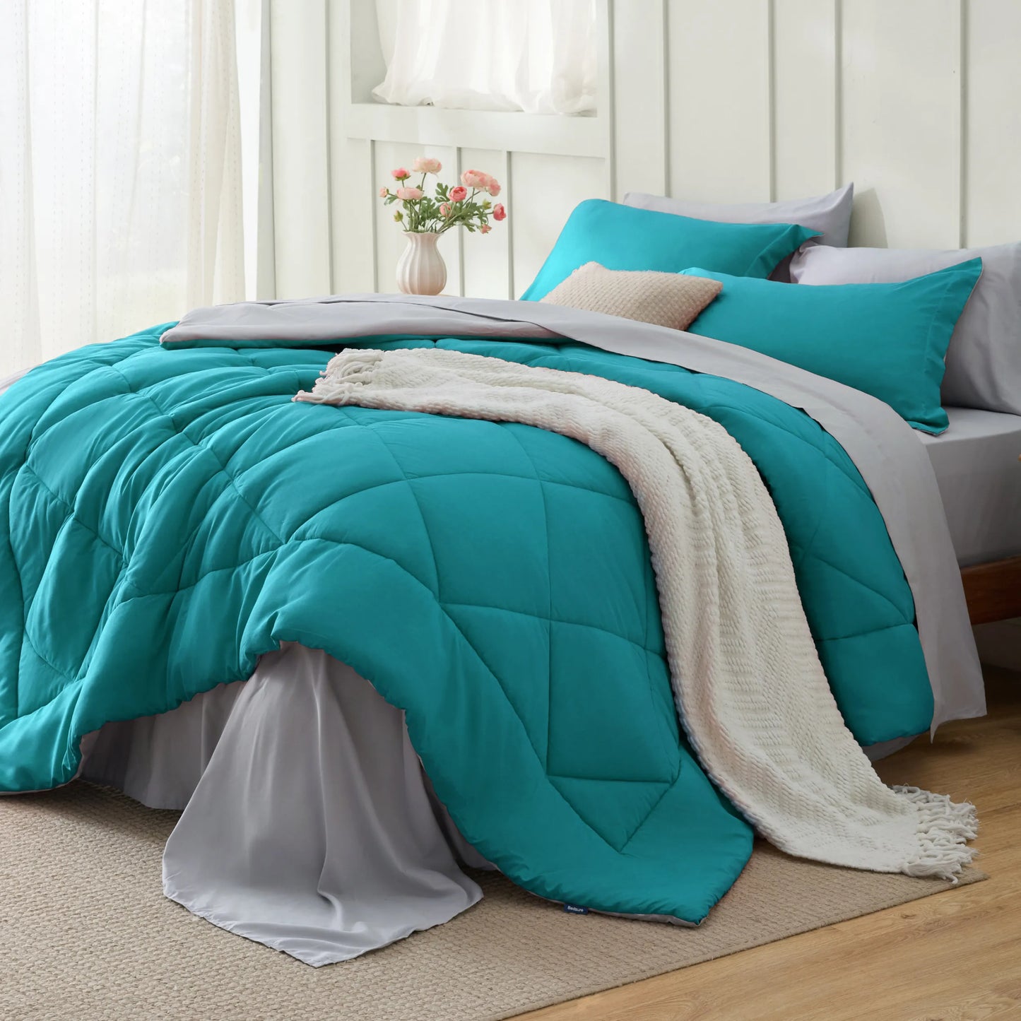 Turquoise quilted reversible bed-in-a-bag set with pillows and white textured throw.