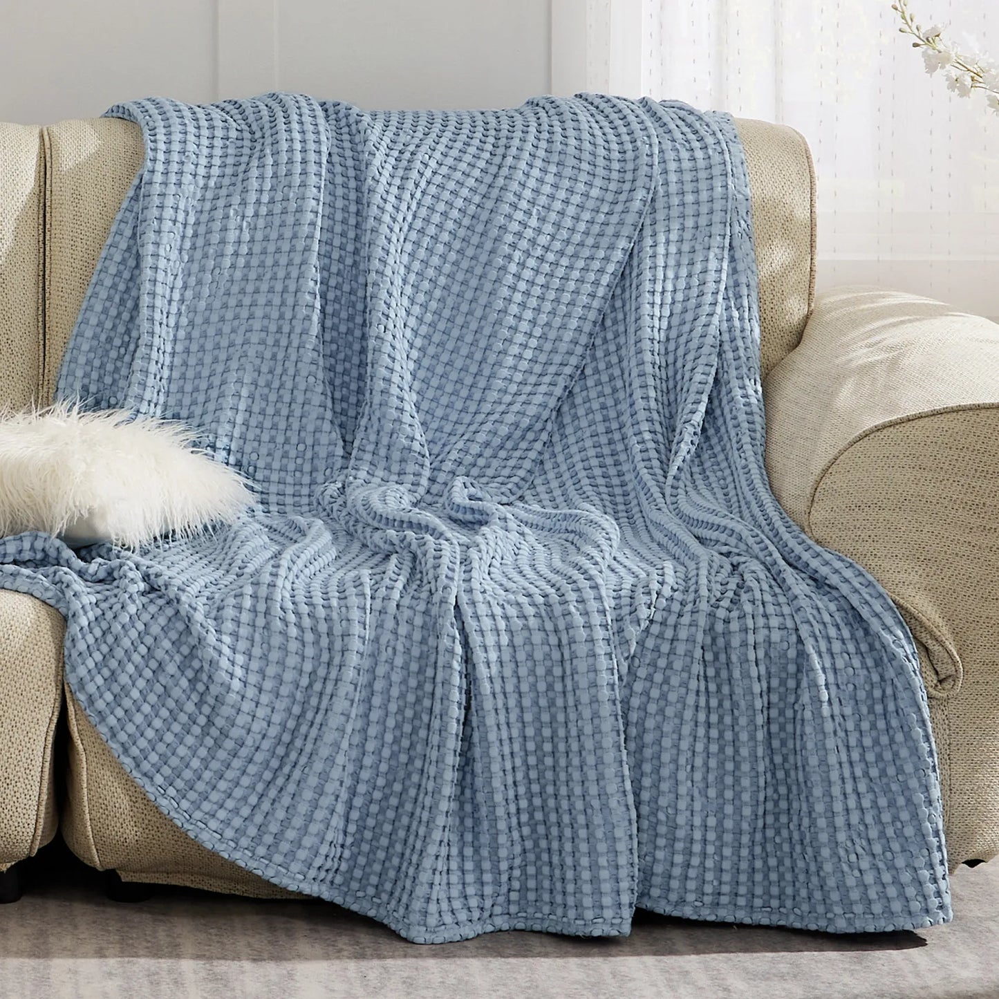 Soft blue waffle weave rayon derived from bamboo blanket on sofa.