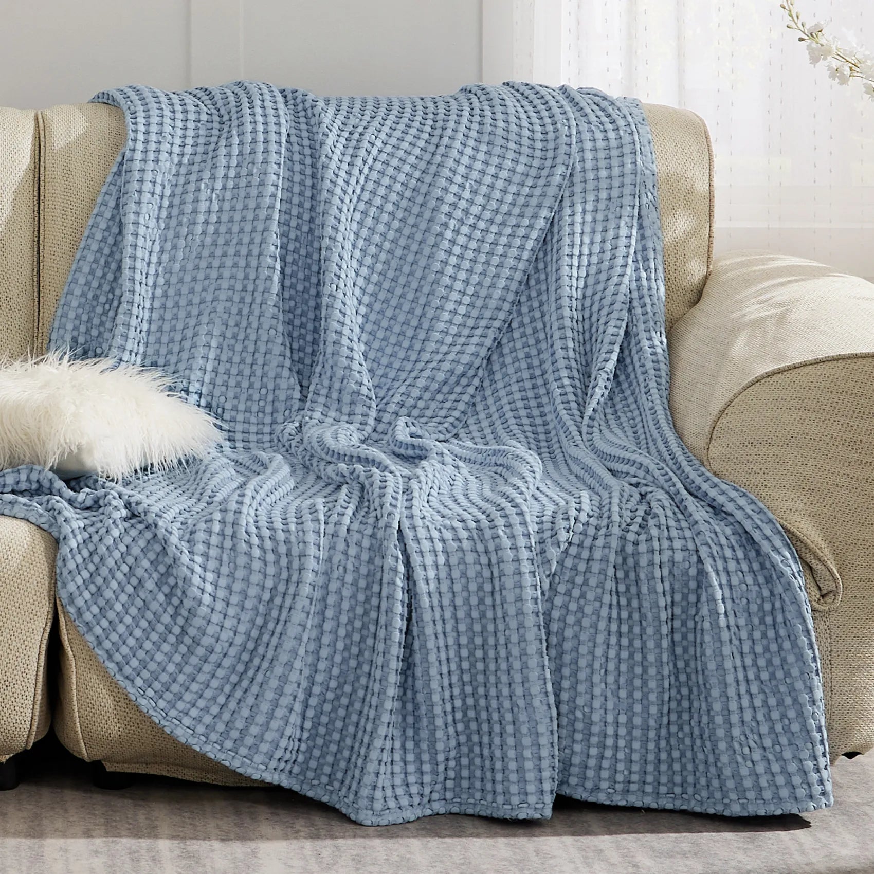Soft blue waffle weave rayon derived from bamboo blanket on sofa.