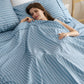 Blue and white striped cotton-like sheet sets offer cozy comfort to sleeping woman.