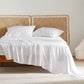 Rayon derived from bamboo plush luxe bedding in white, on bed with woven rattan headboards.