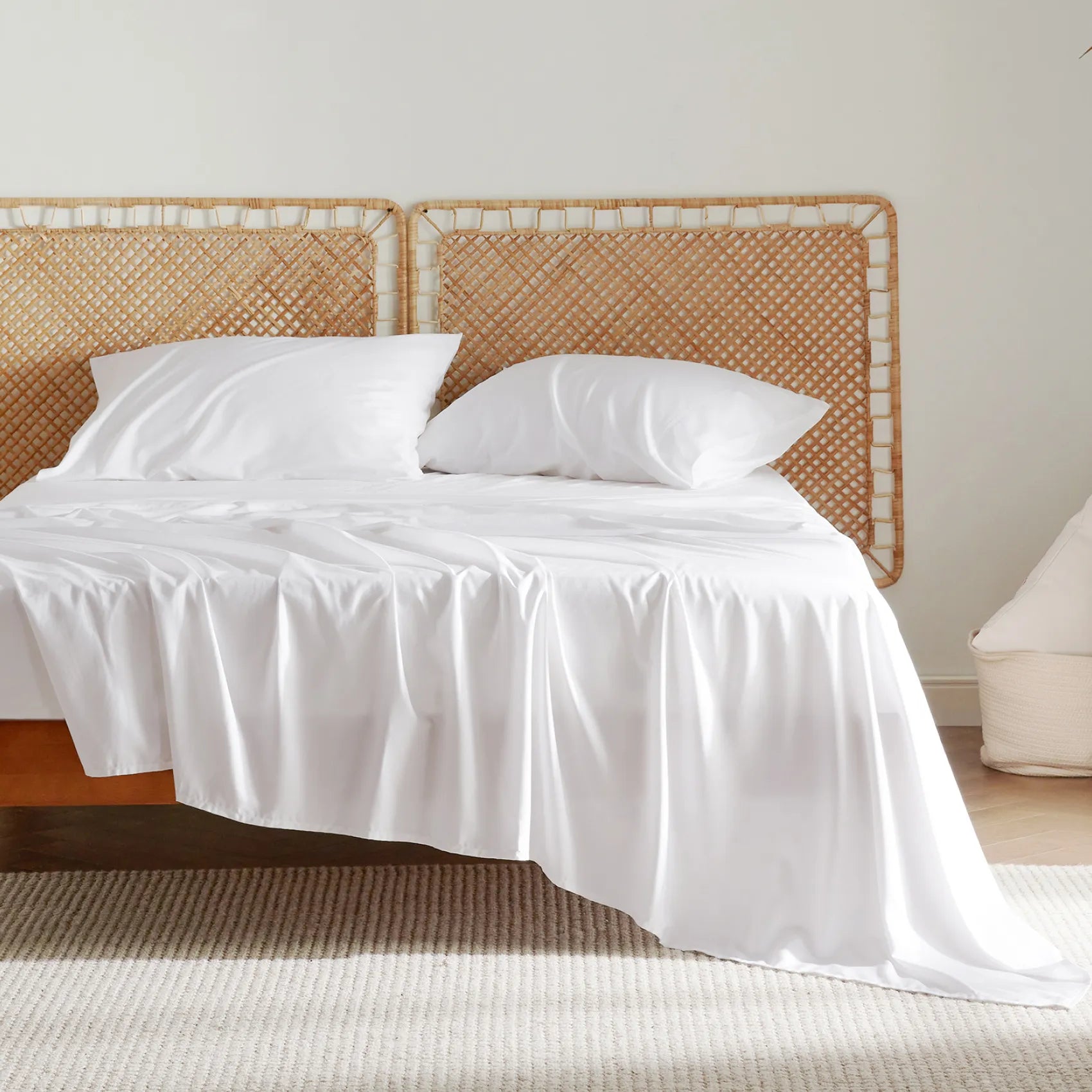 Rayon derived from bamboo plush luxe bedding in white, on bed with woven rattan headboards.
