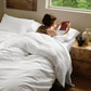 Luxurious white PureWoven™ organic cotton plush bundle, woman reading.