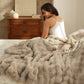 Plush Luxe textured throw blanket in light beige on a bed.