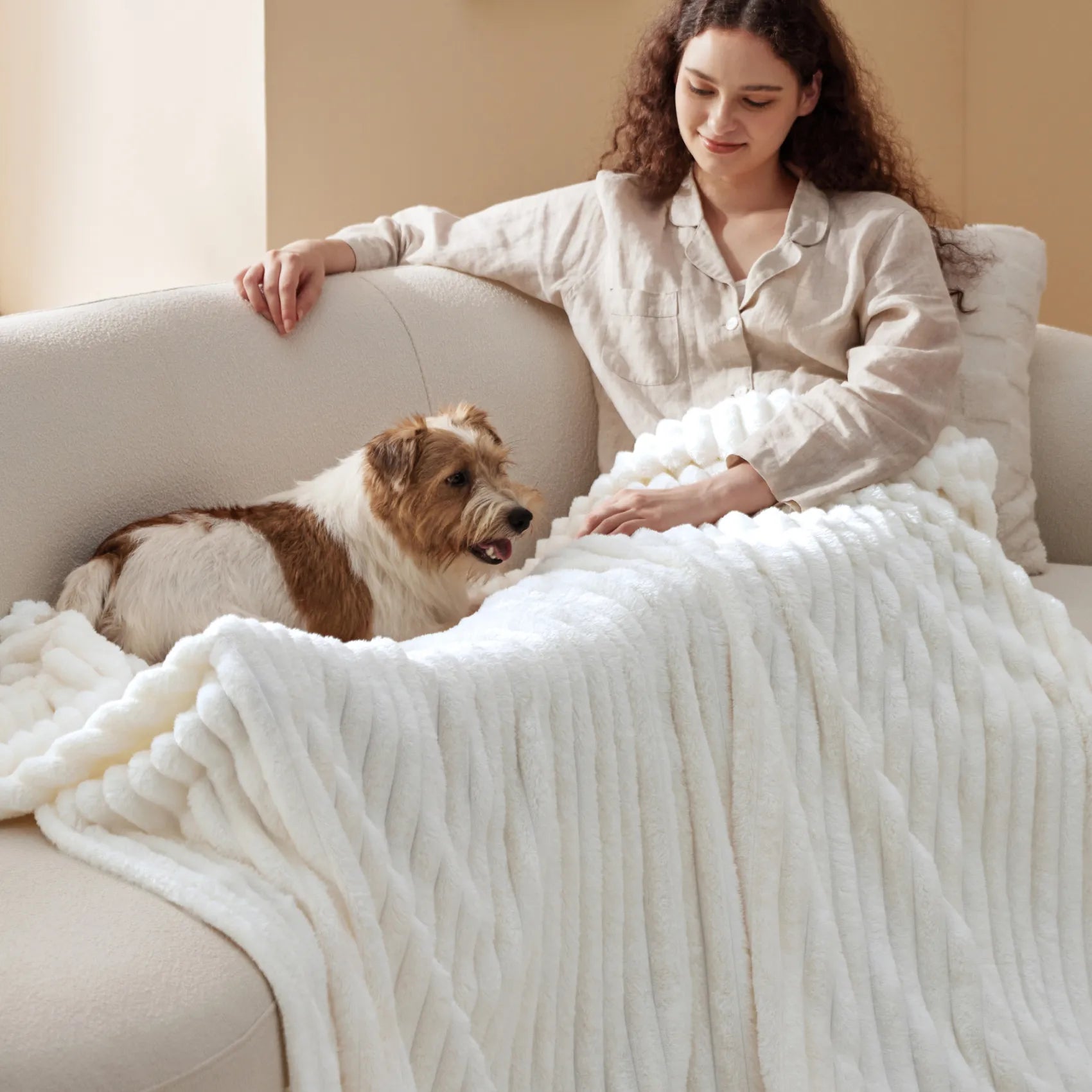 Cozy bundle: Woman & dog relaxing under plush white ribbed blanket.