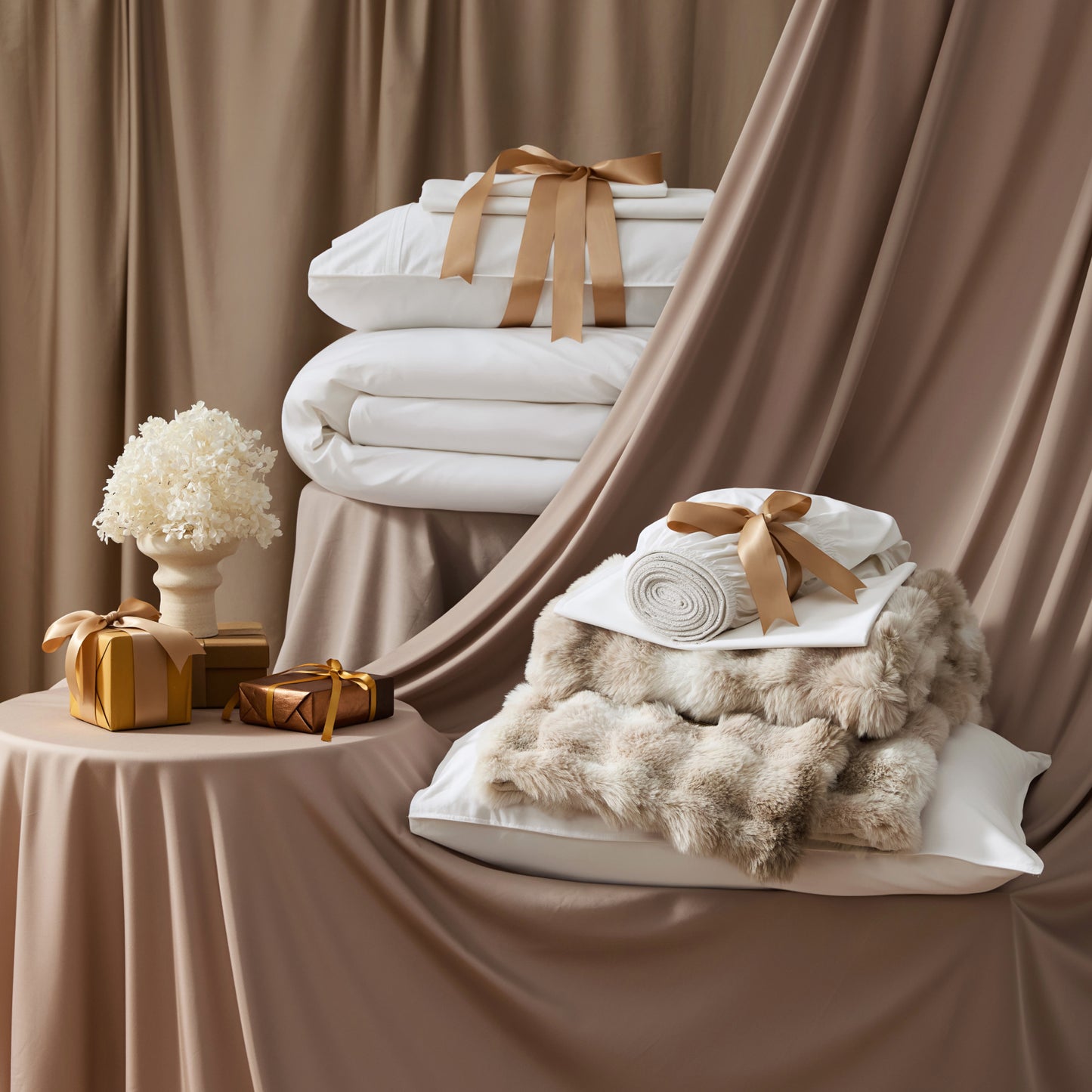 PureWoven™ Organic Cotton Plush Luxe Bundle with white bedding, faux fur blanket, and gifts.