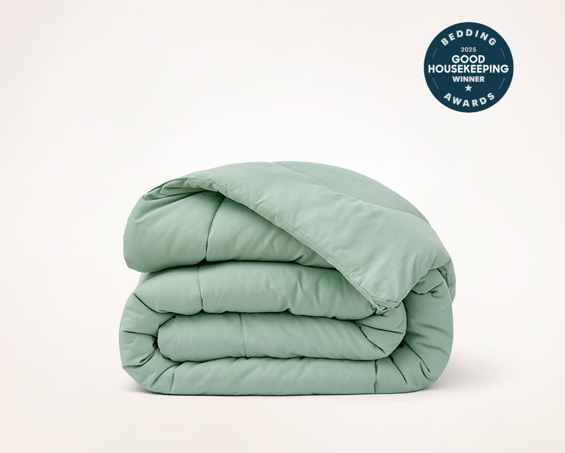 Folded light green comforter with Good Housekeeping Award badge on a white background 