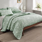 Green botanical quilt set with white floral pattern and diagonal quilting.