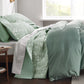 Sage green botanical quilt set with white floral pattern, quilted polyester.