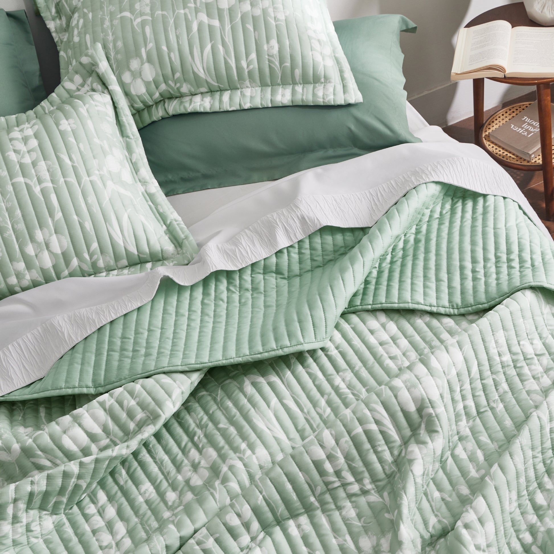 Botanical quilt set in light green with white floral pattern and channel quilting. Polyester.