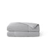 Soft grey nylon cooling comforter, folded, with white piping and breathable texture.