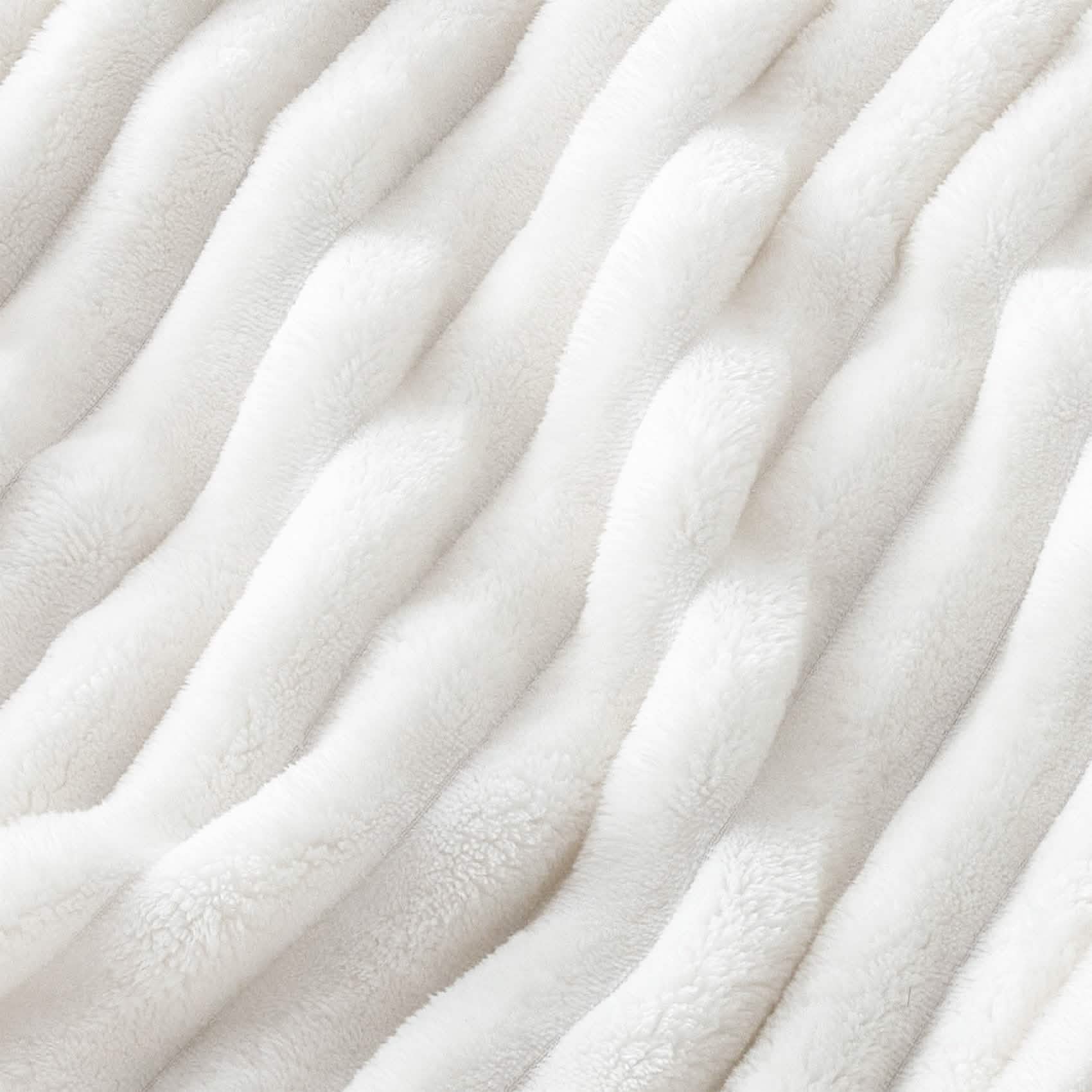 GentleSoft white polyester blanket close-up showing plush ribbed texture, emphasizing softness and material.